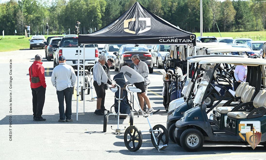 Des golfeurs et leurs voiturettes devant le pavillon du Club de golf Laurier.
